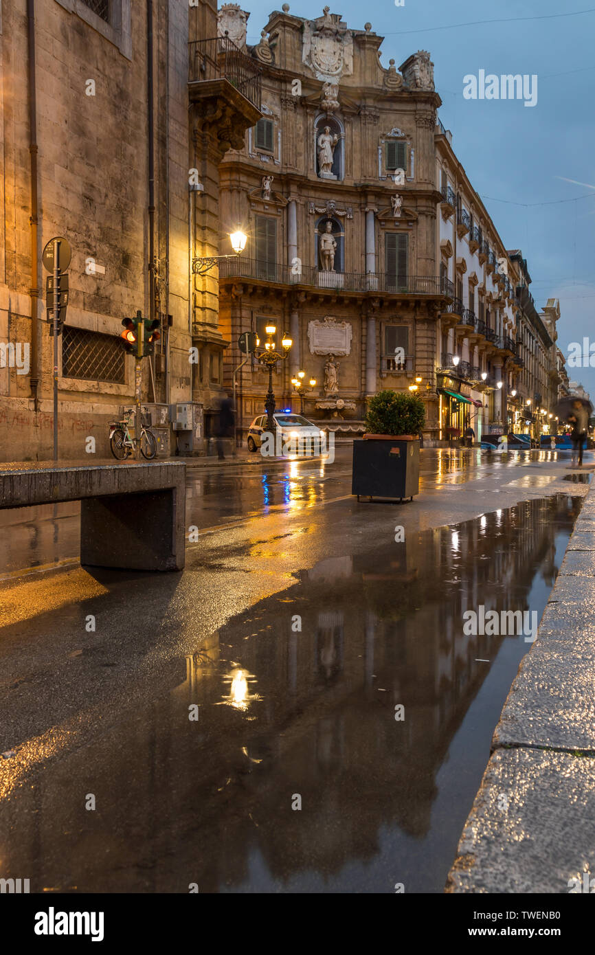 Edifici storici vicino a quatro Canti riflessa in una pozza poco dopo la pioggia, Palermo, Sicilia, Italia, Europa Foto Stock