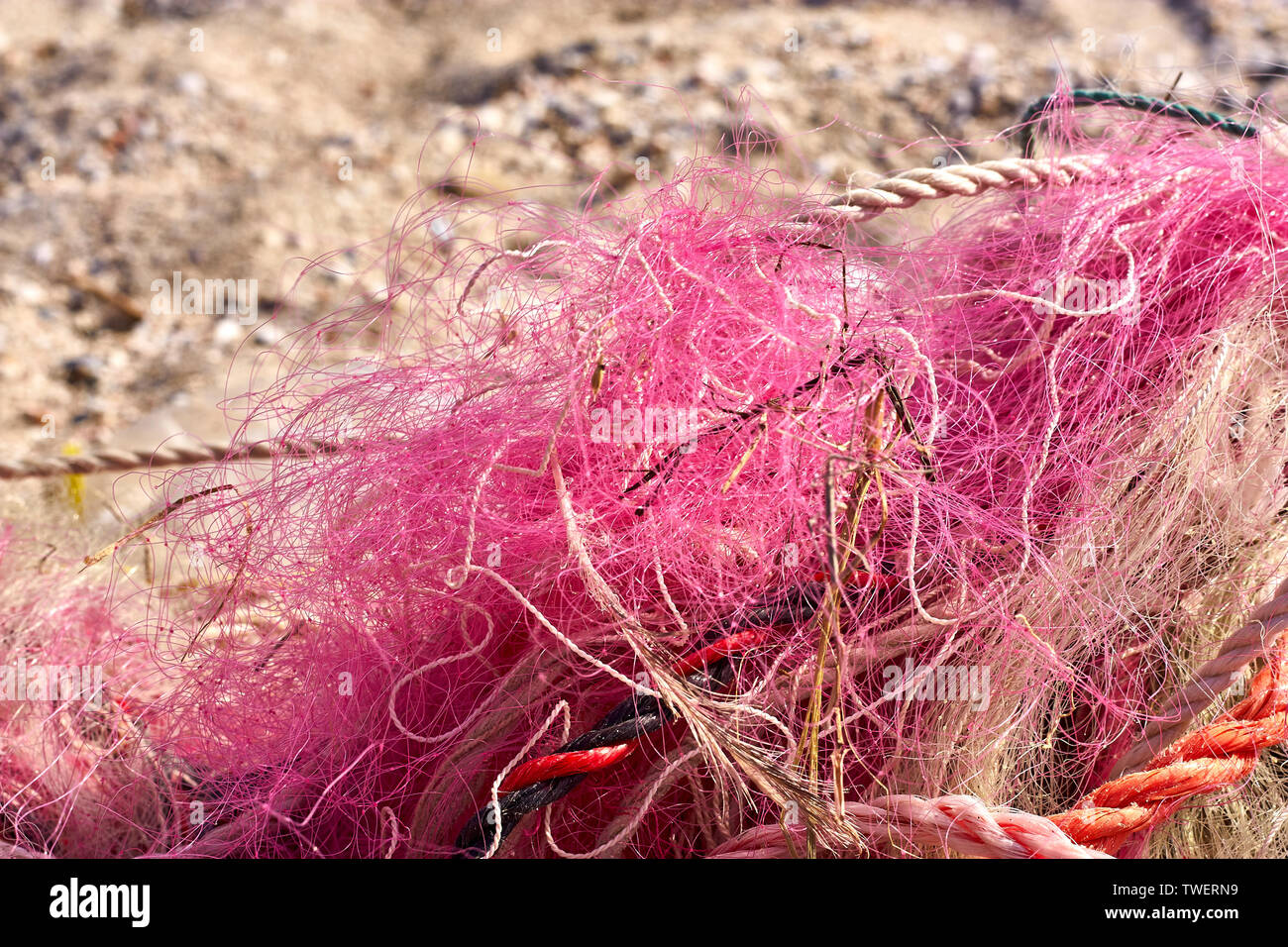 Un ingombro di reti da pesca corda di plastica e altri detriti lavato fino a una spiaggia costiera. Salvare il pianeta stock foto. Foto Stock