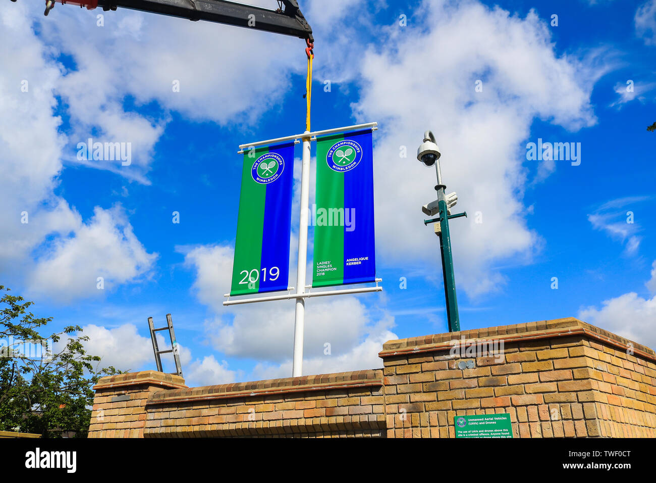 Il torneo di Wimbledon di Londra, Regno Unito. Xx Giugno, 2019. Banner con i nomi di Wimbledon 2018 Uomini e donne singles champions Novak Djokovic (Serbia) e Angelique Kerber (Germania) vengono sollevati da un carrello su i cancelli del AELTC che si prepara ad ospitare i campionati di Wimbledon Credito: amer ghazzal/Alamy Live News Foto Stock