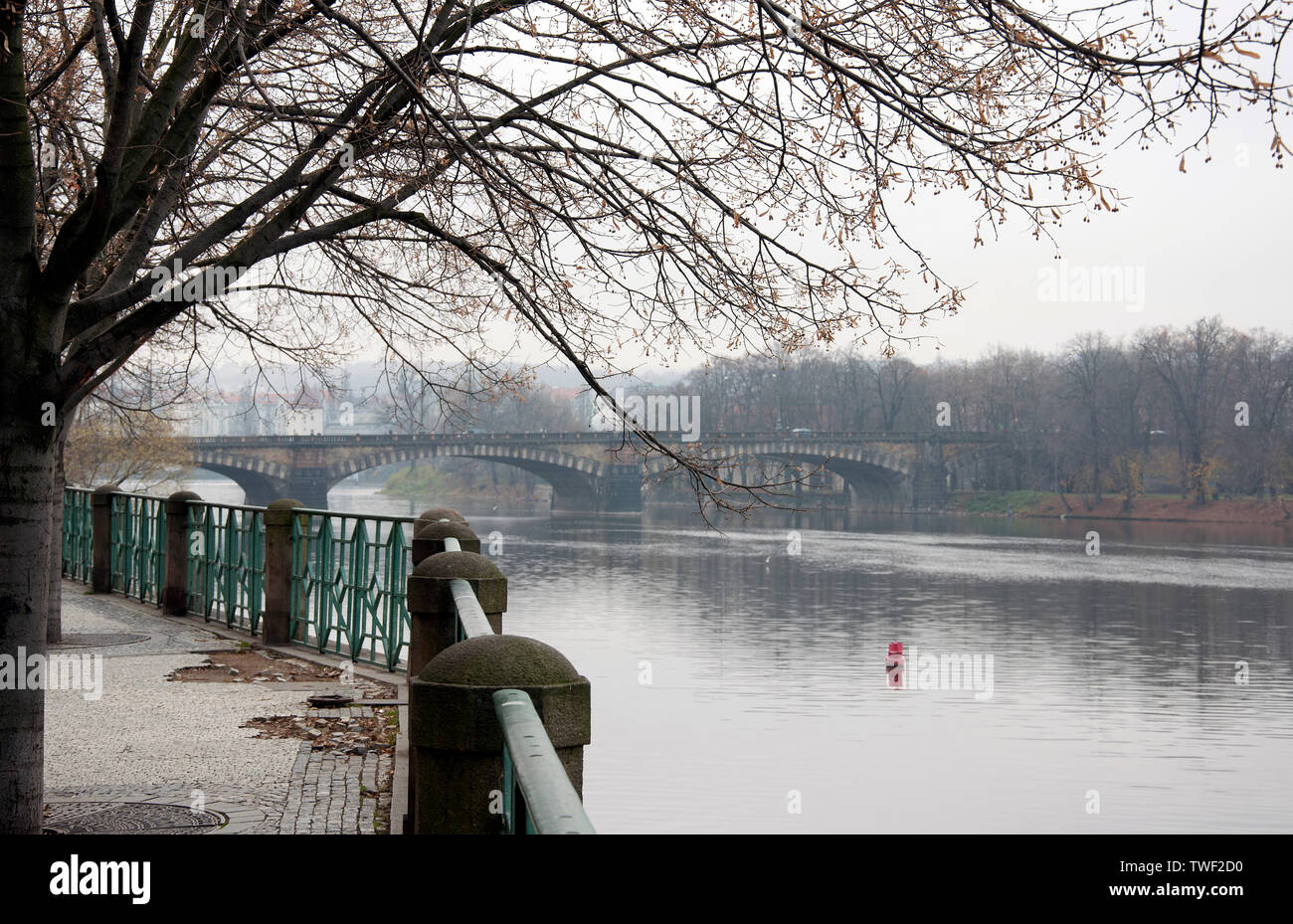 Un ponte sul fiume Moldava a Praga in autunno, accanto a un lastricato in pietra promenade. Panorama di Praga. Repubblica Ceca Città vecchia architettura Pier. Foto Stock