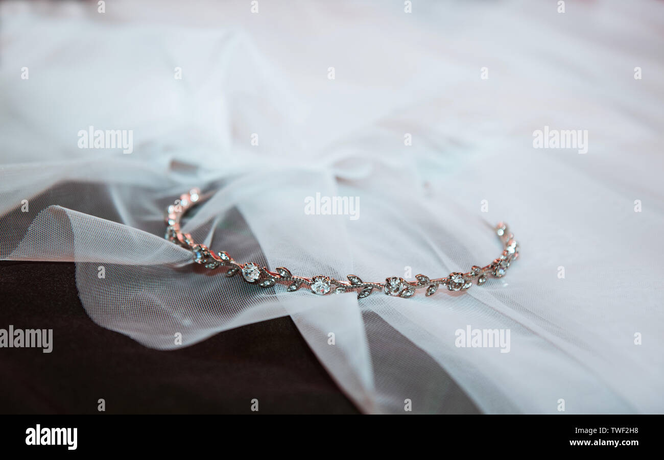 Nozze d'oro Anello con diamanti giacente sul velo della sposa Foto Stock