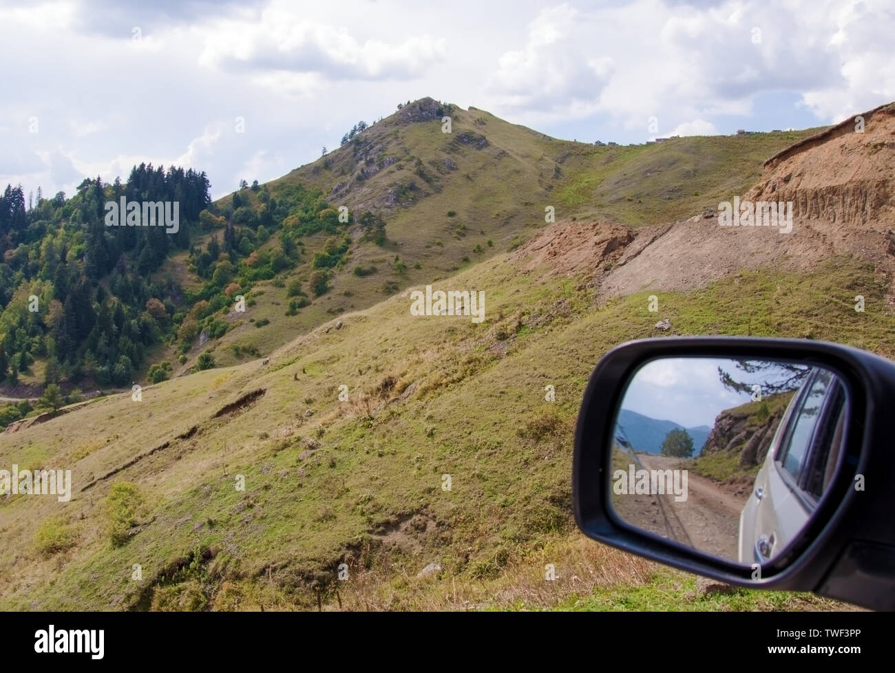 La riflessione di una strada di montagna in un specchio auto in Georgia Foto Stock
