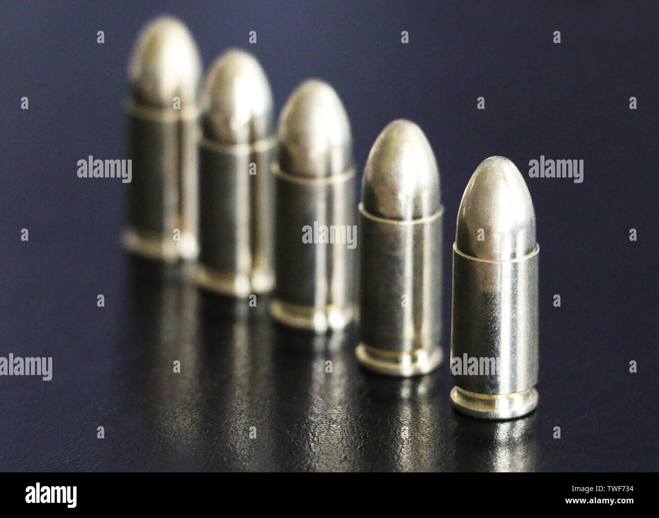 Close up di 9 mm pistola dorata proiettili munizioni sullo sfondo. Forza speciale unità. Foto Stock