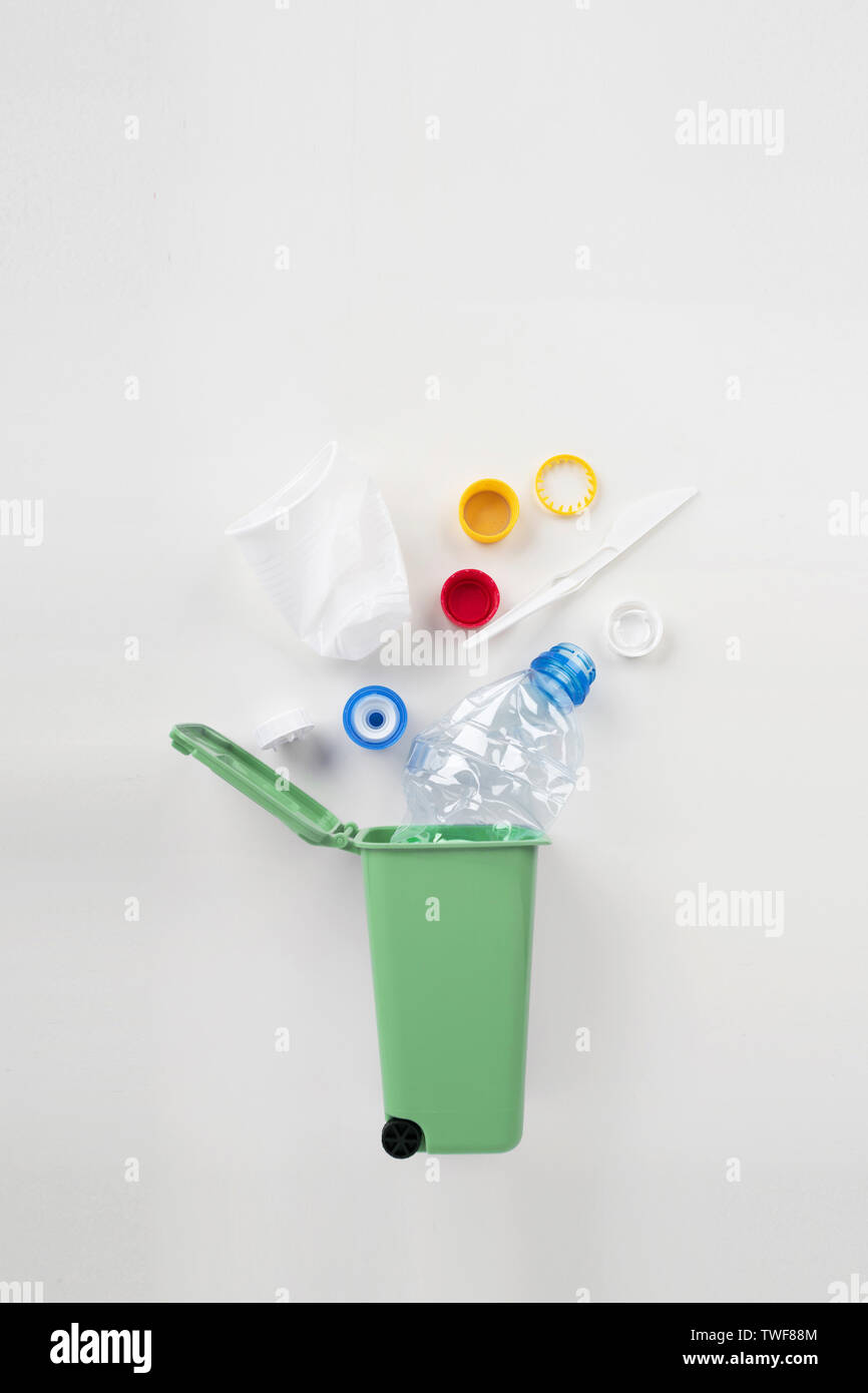 Cestino con rifiuti di plastica su sfondo grigio. Concetto di riciclaggio Foto Stock