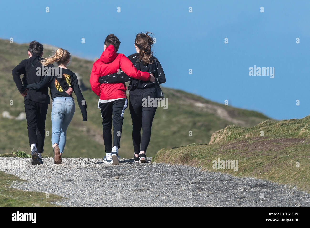 Giovani adolescenti con le loro braccia intorno a ogni altro a piedi lungo un sentiero. Foto Stock