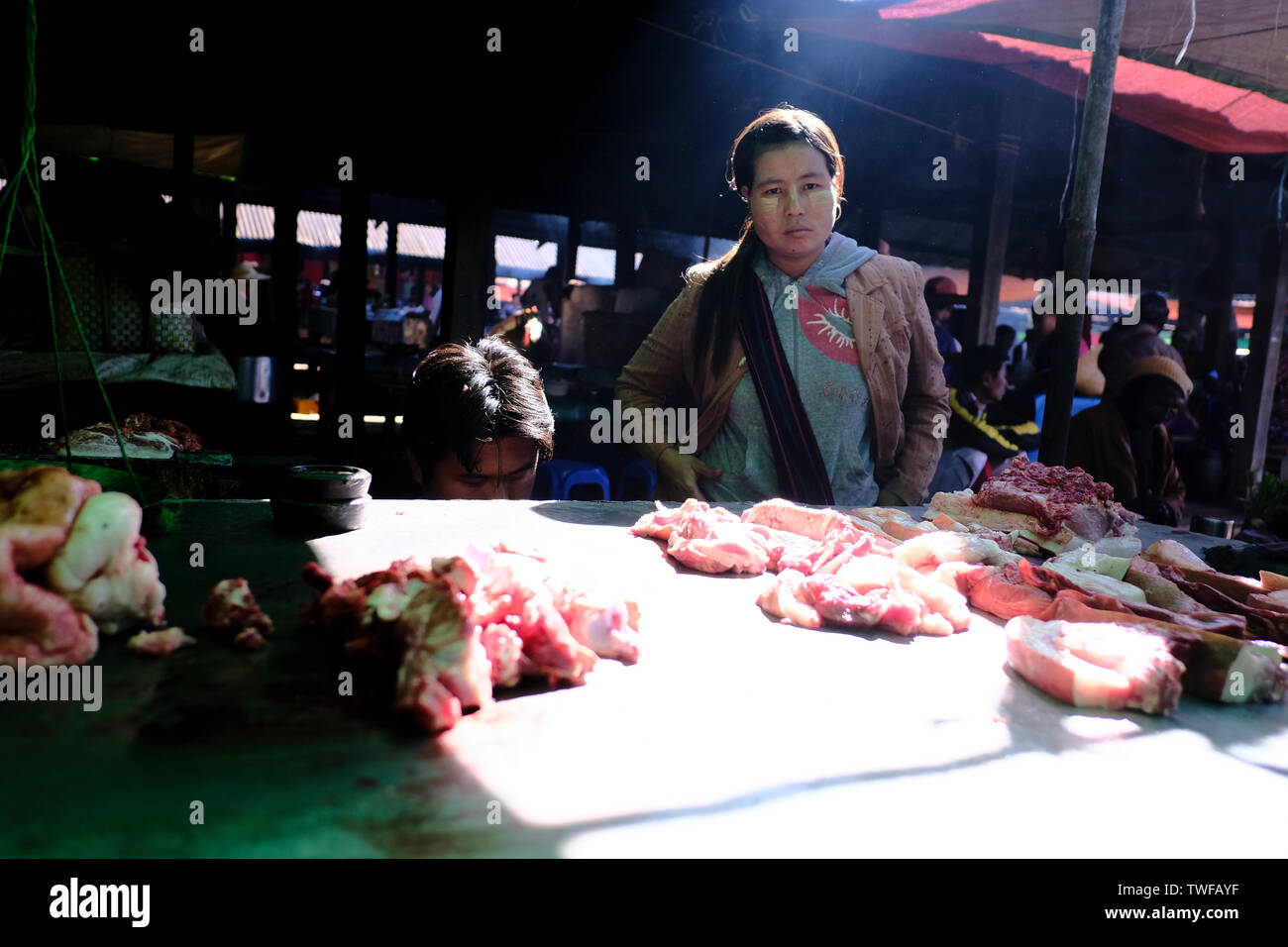 Una donna vende carne ad un mercato birmano. Foto Stock