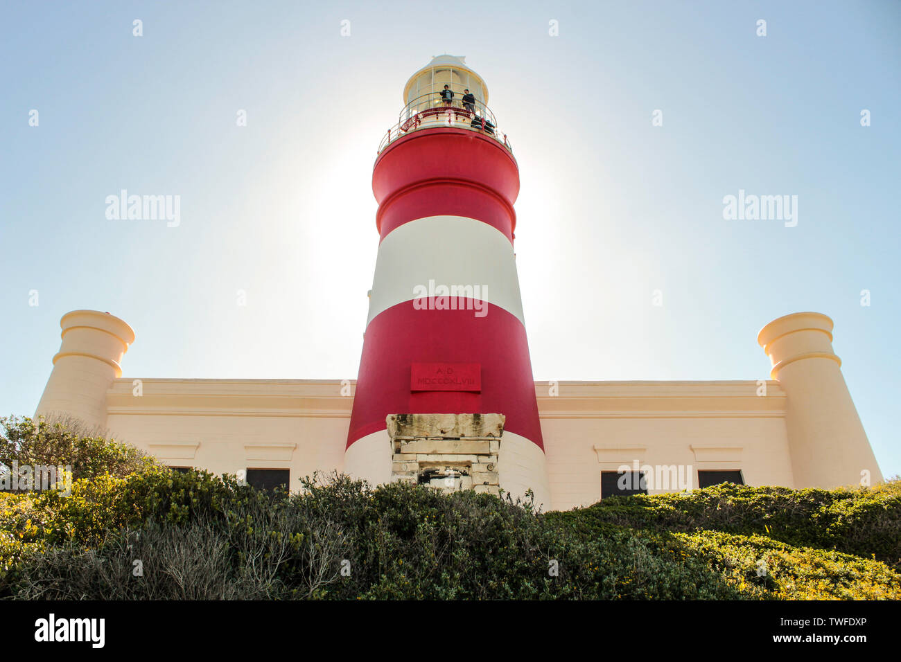 Cape Agulhas Lighthouse retroilluminati da sole in un giorno chiaro. Foto Stock