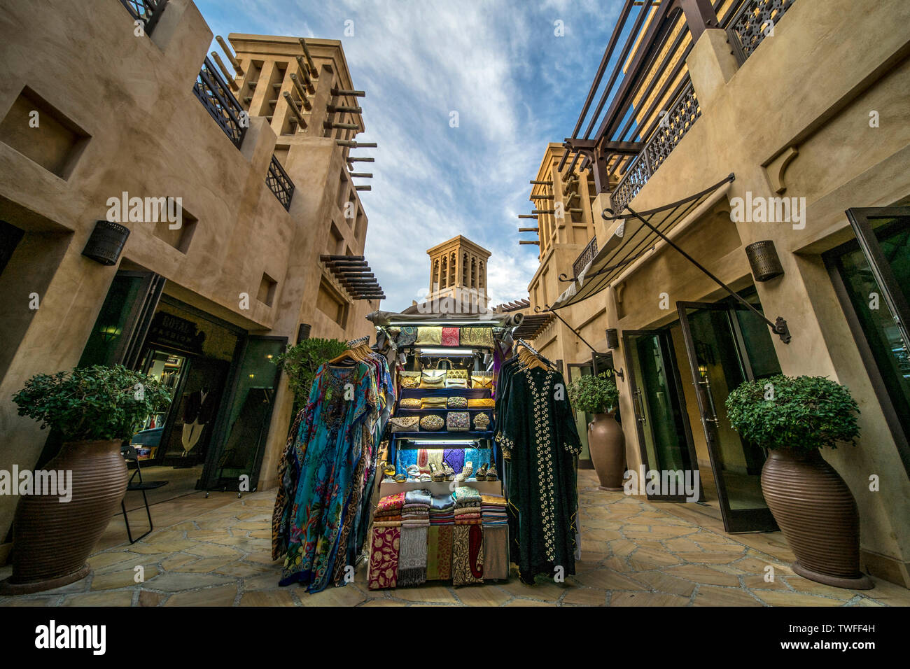 Un commerciante in stallo piena di colorati arabo merchandise lungo i sentieri di un marketplace di Dubai. Foto Stock