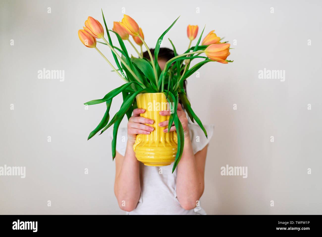 Ritratto di una ragazza con un vaso di tulipani Foto Stock