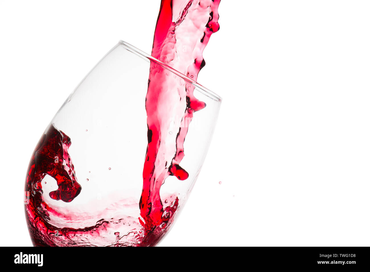 Close up dell'onda formata sul versamento di vino rosso su un bicchiere da degustazione contro uno sfondo bianco Foto Stock