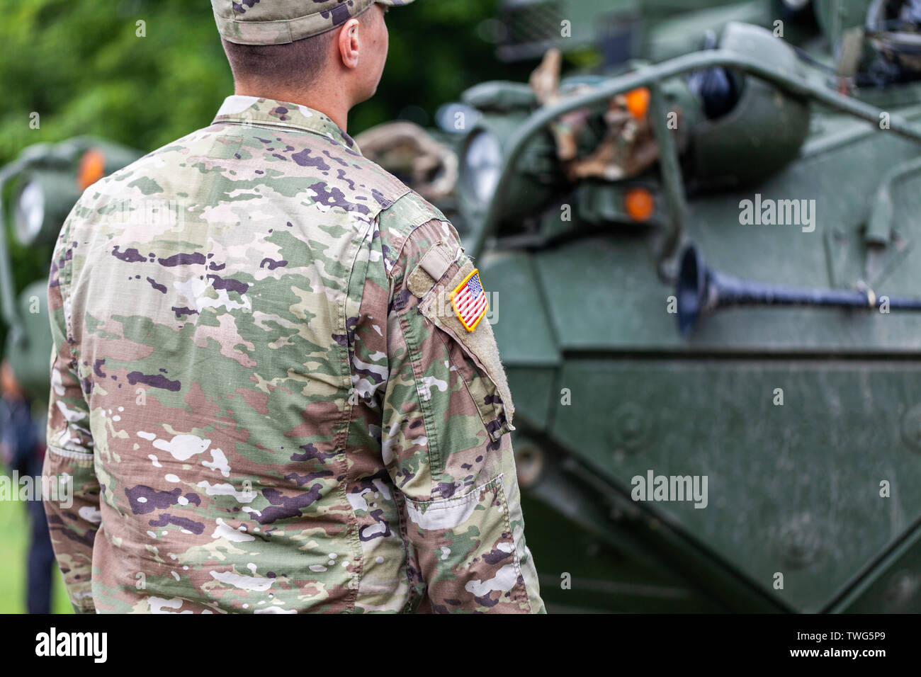 Un soldato dell'esercito degli Stati Uniti sta di fronte ad un combattimento corazzati veicolo Foto Stock