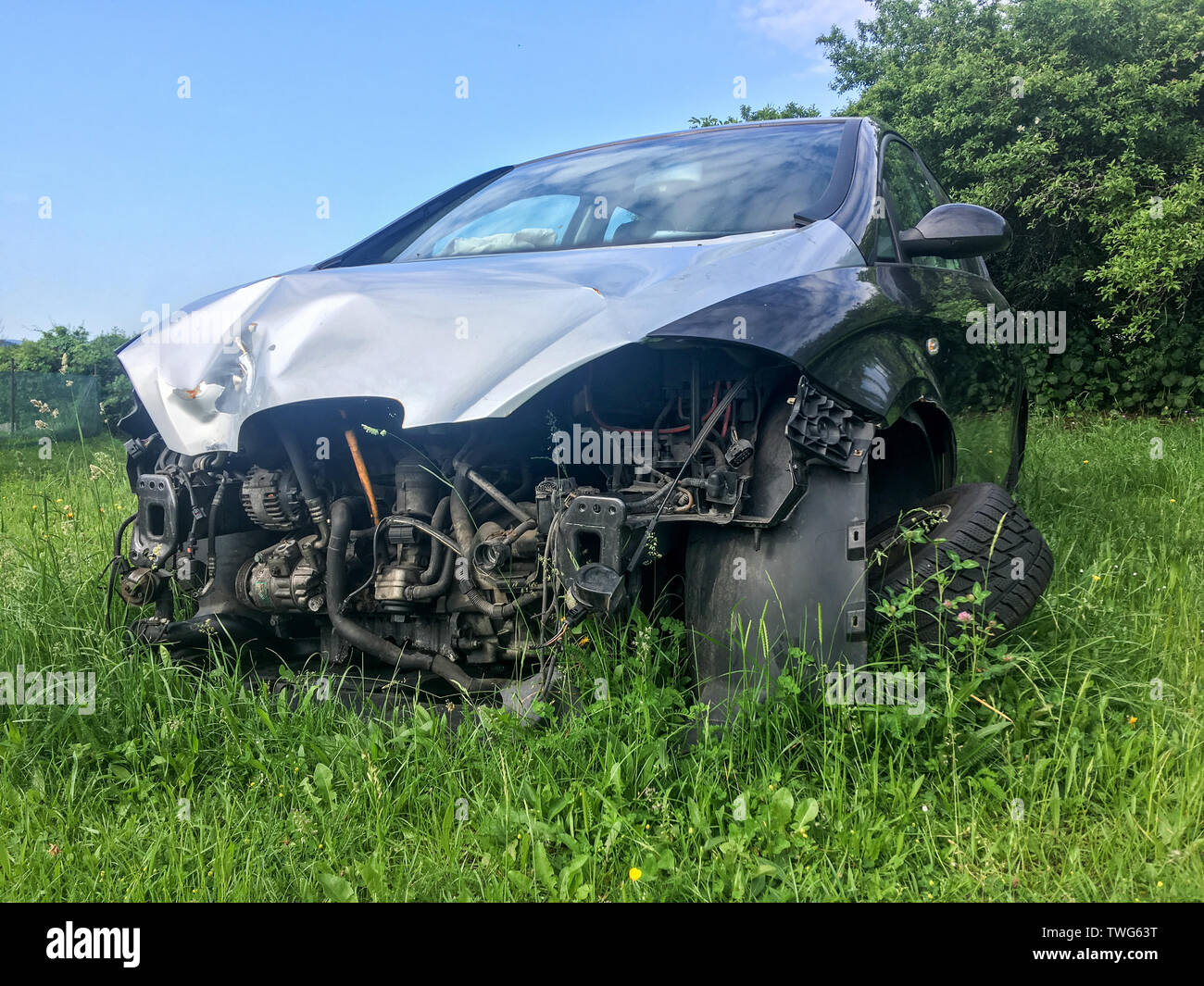 Il relitto della vettura è in piedi sul prato con ruota rotto e senza le parti anteriori. Forse dopo lo scontro frontale. Foto Stock