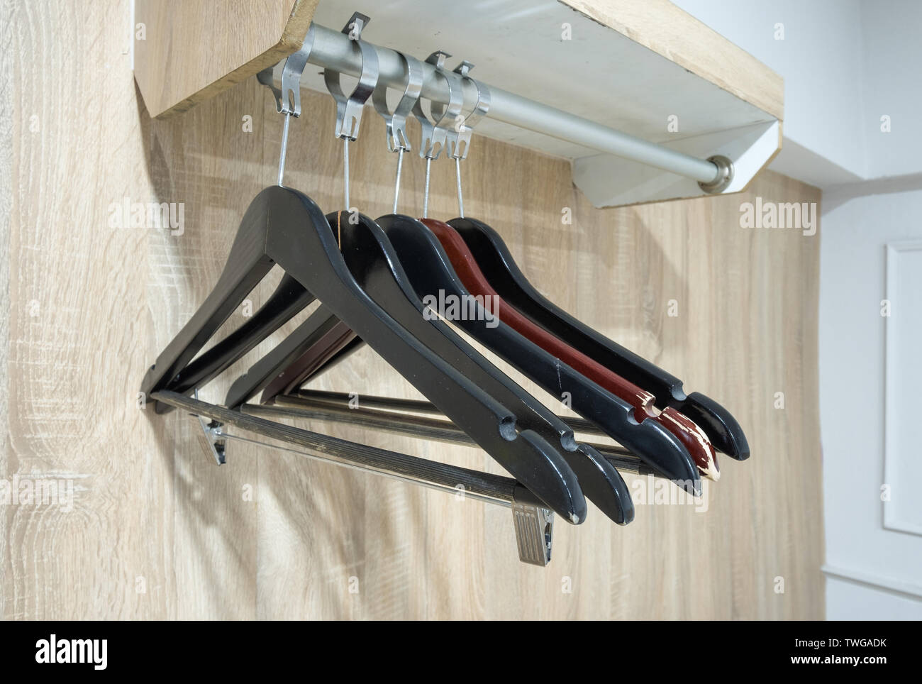 Appendiabiti vuoto su rotaia in armadio in legno Foto Stock