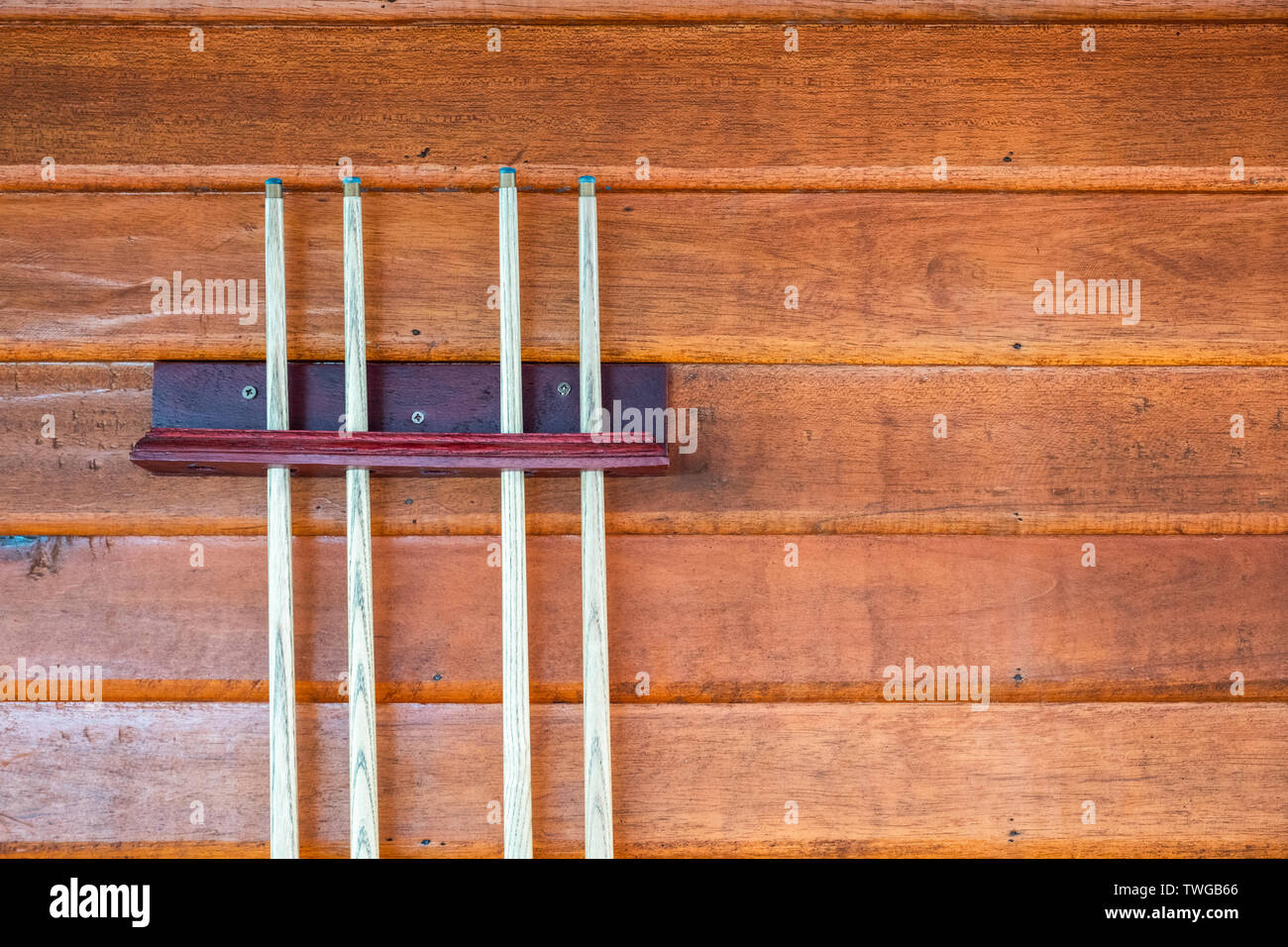 Raccolta di cue di legno o bastoncini di legno sulla parete per snooker e biliardo Foto Stock