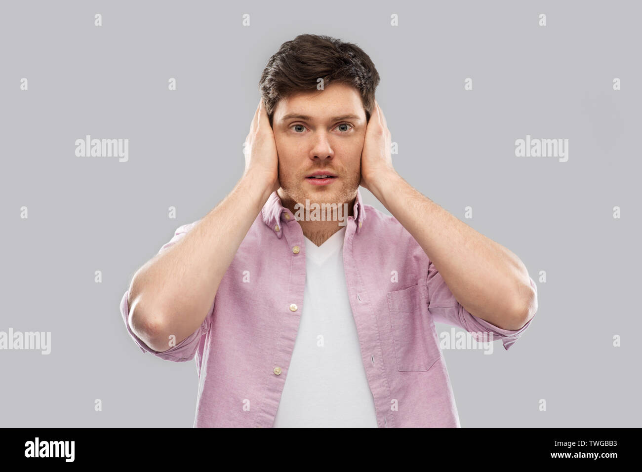 Uomo di chiudere le orecchie con le mani Foto Stock