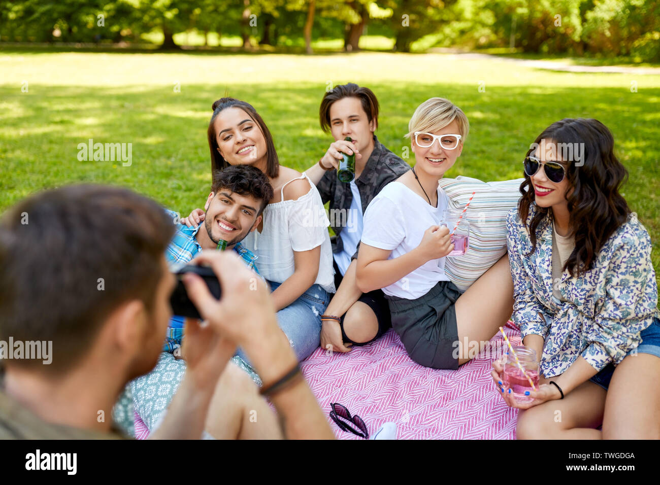 Amici con bevande a fotografare al picnic estivo Foto Stock