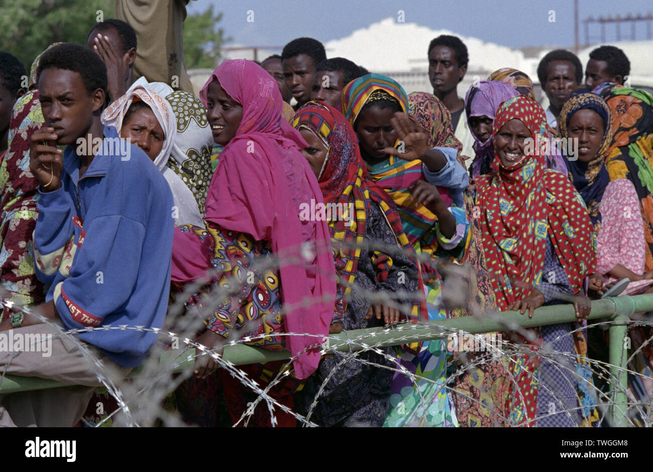 5 novembre 1993 somali locale coda dietro al filo spinato all'ingresso della sede UNOSOM composto a Mogadiscio, in Somalia. Foto Stock