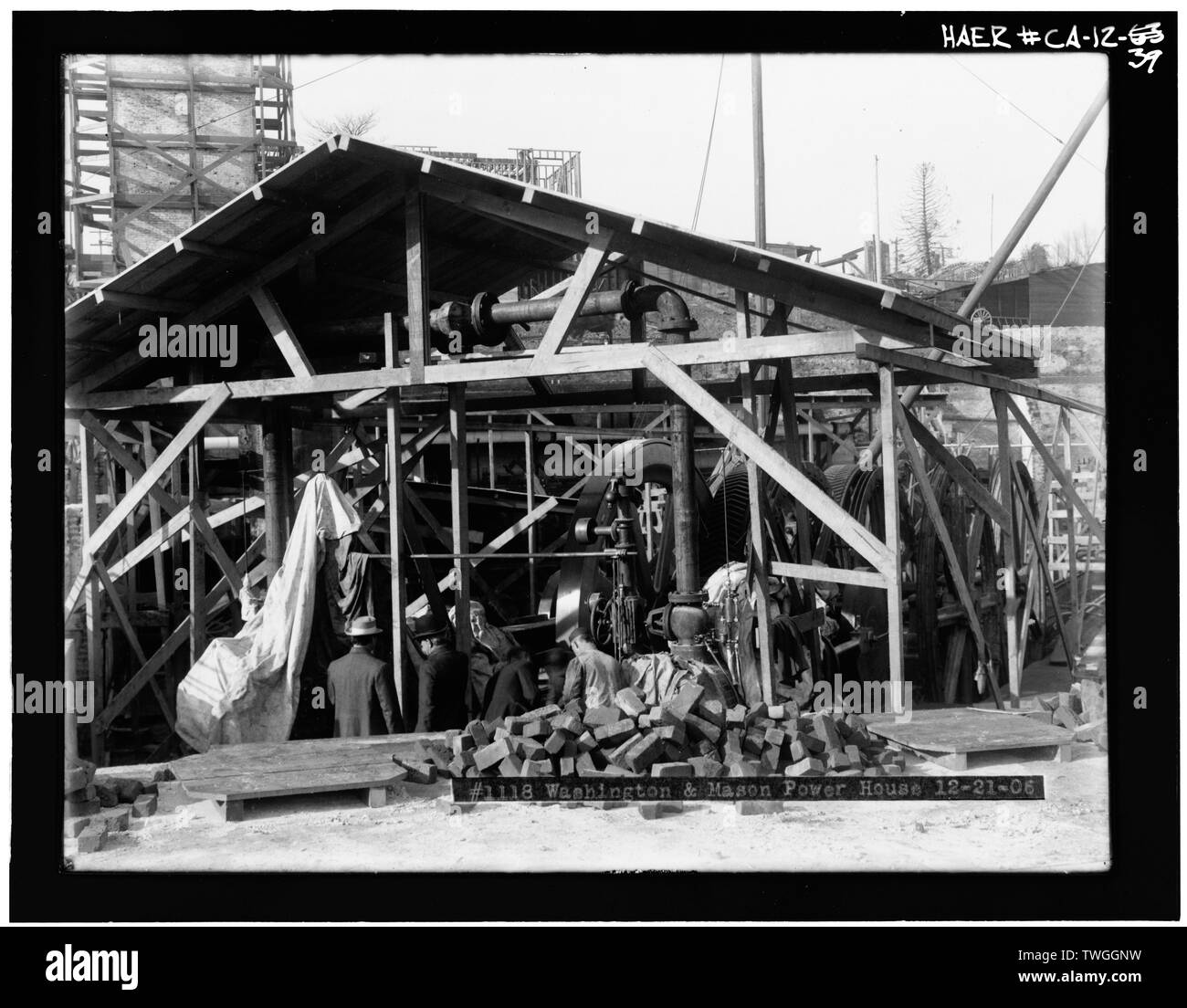 Ricostruita per motori e macchine di avvolgimento- fotocopia del dicembre 1906 fotografia dei motori a vapore e macchine di avvolgimento a Washington e Mason Street e potente. Vista verso ovest. Regno Ferrovie di San Francisco ricostruito i motori danneggiati e gli avvolgitori mostrato in CA-12-60 e CA-12-61. Non ci sono cavi infilati su macchine bobinatrici in questa fotografia, indicante che l'impresa aveva ancora di riprendere servizio. Nota La ruvida capannone eretto sopra i motori per proteggerli da meteo mentre sono proseguiti i lavori per la ricostruzione del potente. - San Francisco Funivia, Washington e Mason Stre Foto Stock