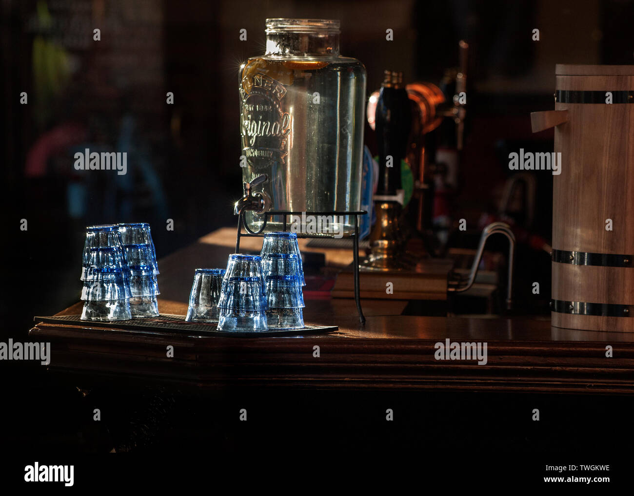 Bar interno del Grafton pub, Kentish Town, bicchieri e dispenser acqua illuminata dal sole, Foto Stock