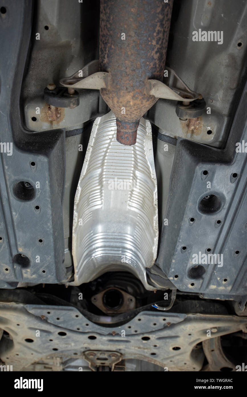 La Toyota Prius, rubato il convertitore catalitico. Vista al di sotto del veicolo dalla meccanica di un pozzetto di ispezione, che mostra la posizione del mancante e i componenti danneggiati. Foto Stock