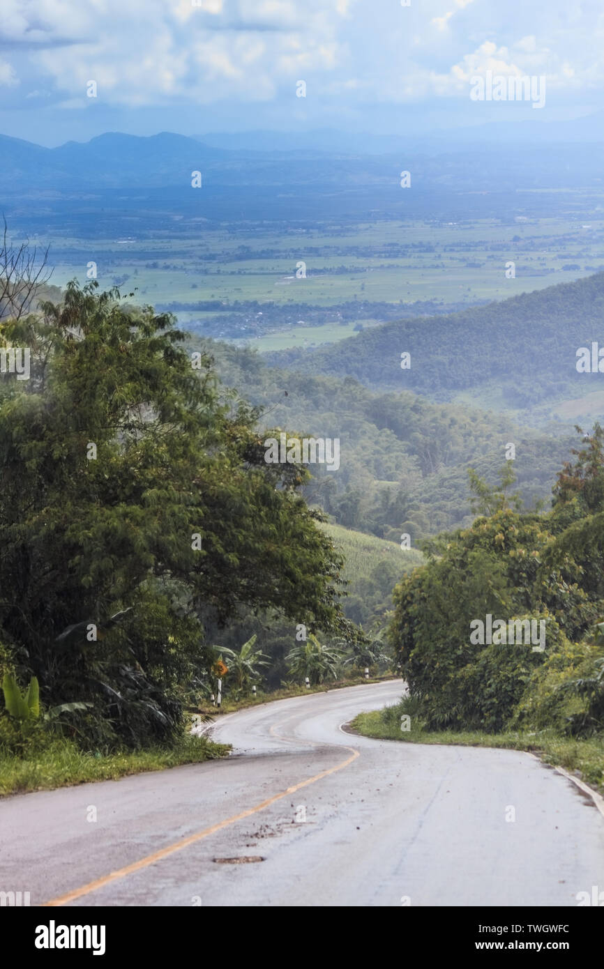 Discesa a umido e strada curva di guidare con cautela. Ridurre la velocità e usare una marcia inferiore. Foto Stock