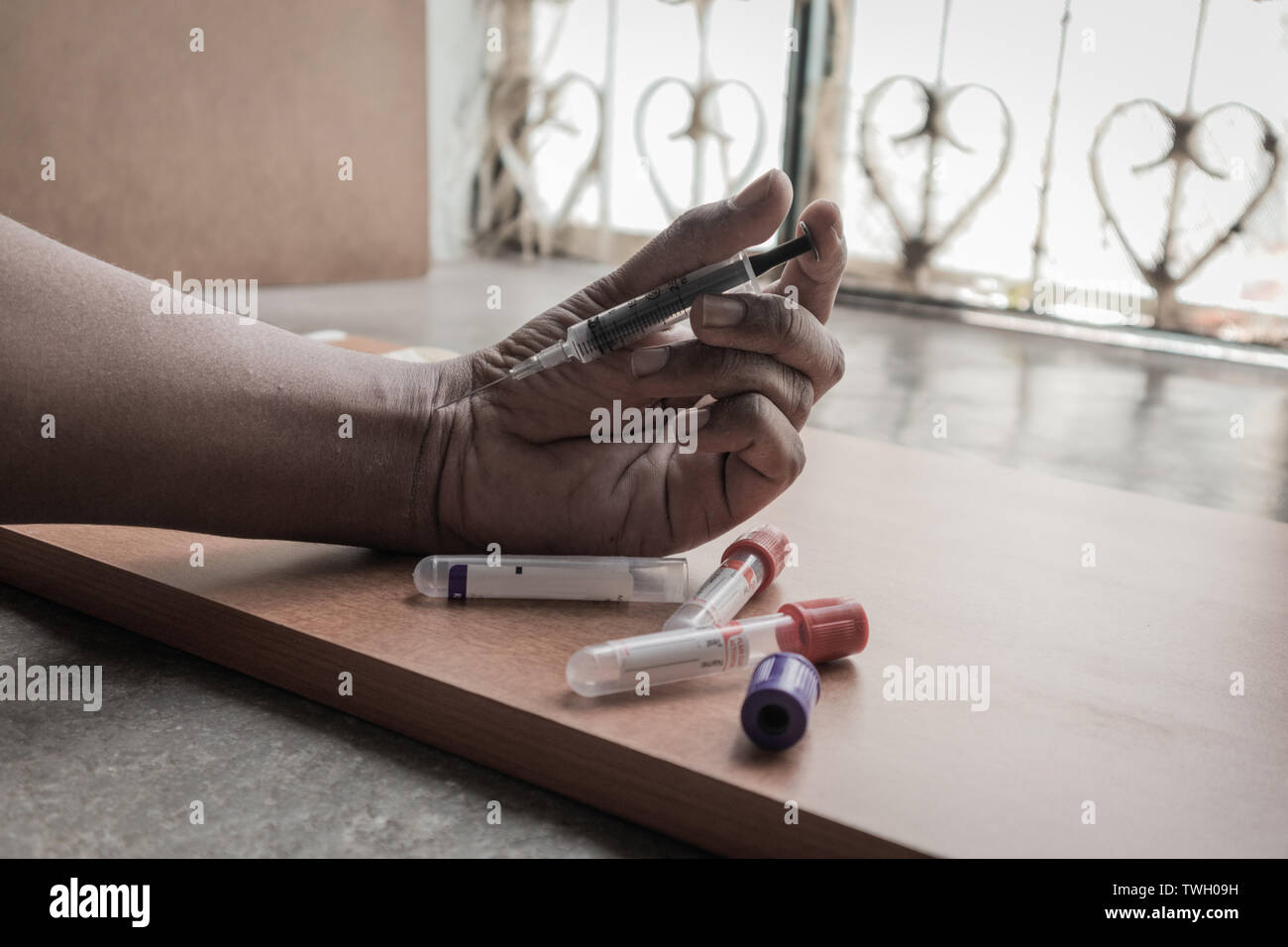 Primo piano della mano del narcotist iniettare la siringa in mano Foto Stock