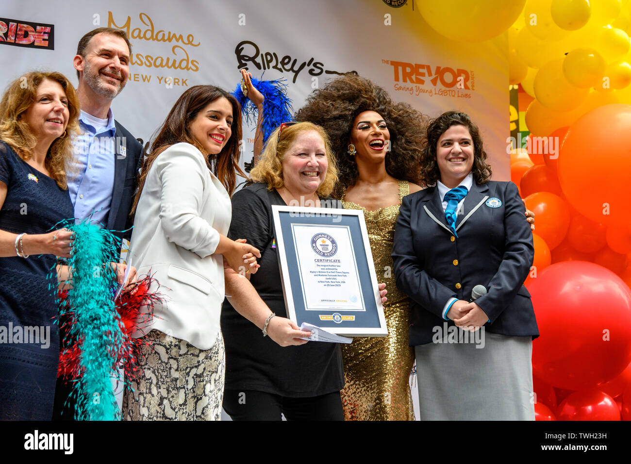 New York, Stati Uniti d'America, 20 giugno 2019. Stacy Shuster, Vice Presidente di Crederci o no di Ripley! Times Square riceve il certificato da un funzionario da Guinness World Record dopo l'impostazione del Guinness World Record titolo della più lunga piuma boa a 1,2 miglia. La manifestazione è stata organizzata da Ripley's credere o non! E Madame Tussauds nella celebrazione del WorldPride e per commemorare il cinquantesimo anniversario di Stonewall insurrezione. Credito: Enrique Shore/Alamy Live News Foto Stock