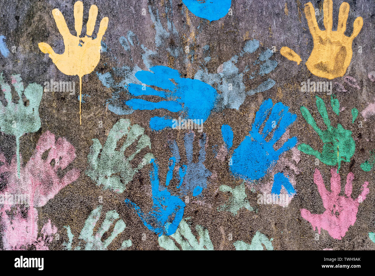 Sfondo scuro con colorati handprints simboleggia interracial amicizia Foto Stock