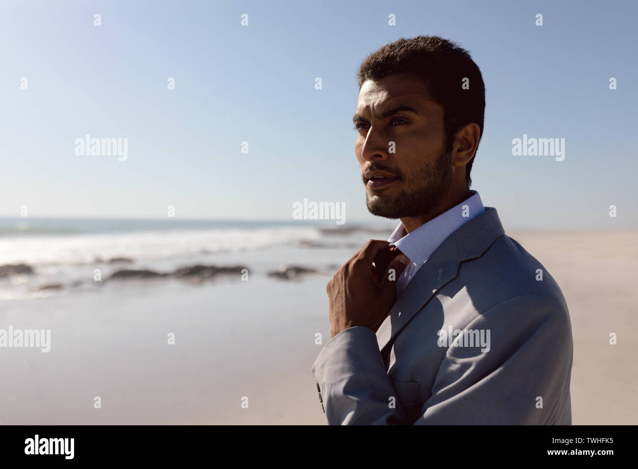 Giovane Imprenditore regolando il suo tirante sulla spiaggia Foto Stock