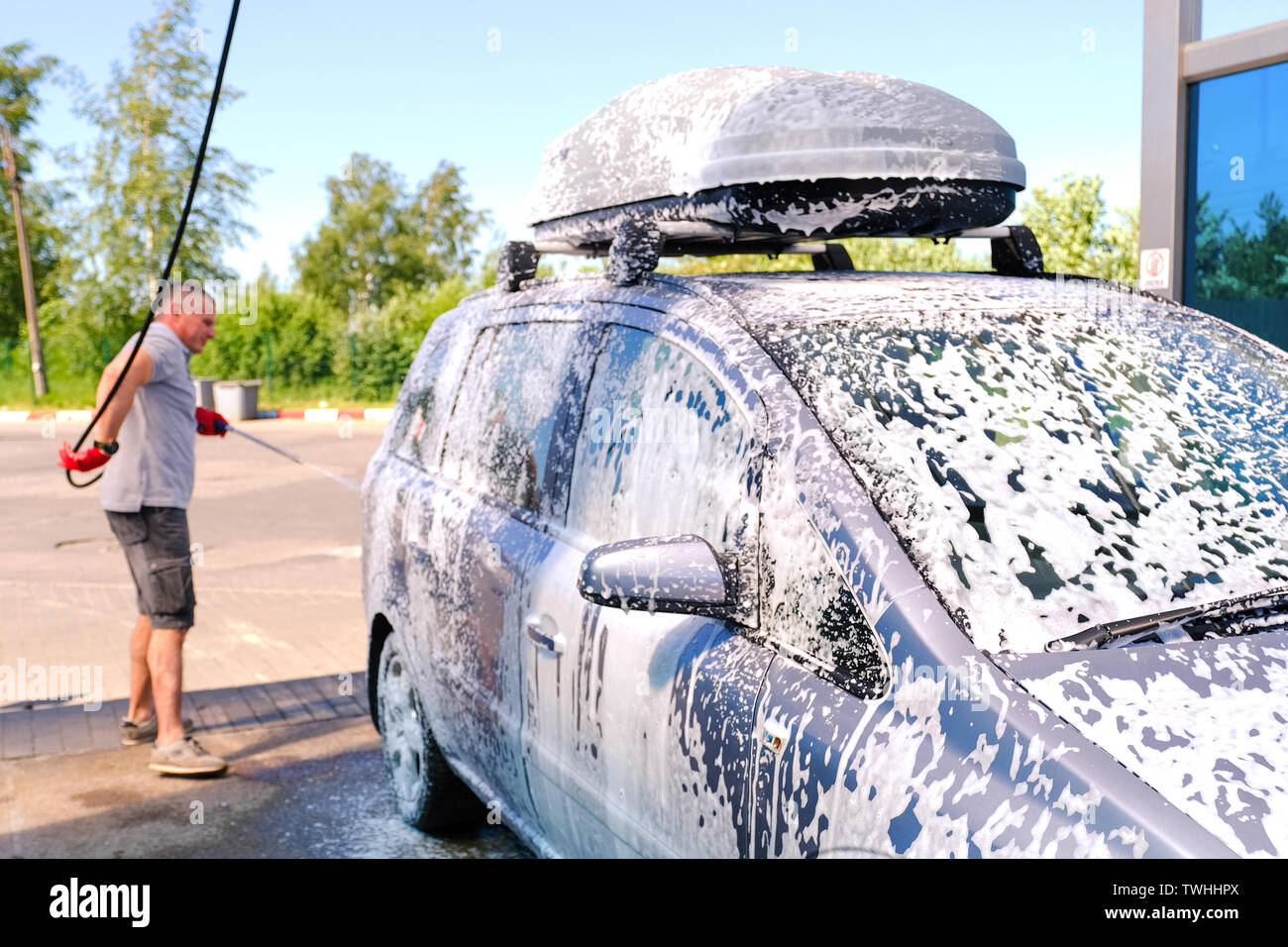 L'uomo versa la schiuma attiva il corpo vettura. Car Wash. Self-service  lavaggio complessi. Alta pressione di lavaggio auto Foto stock - Alamy