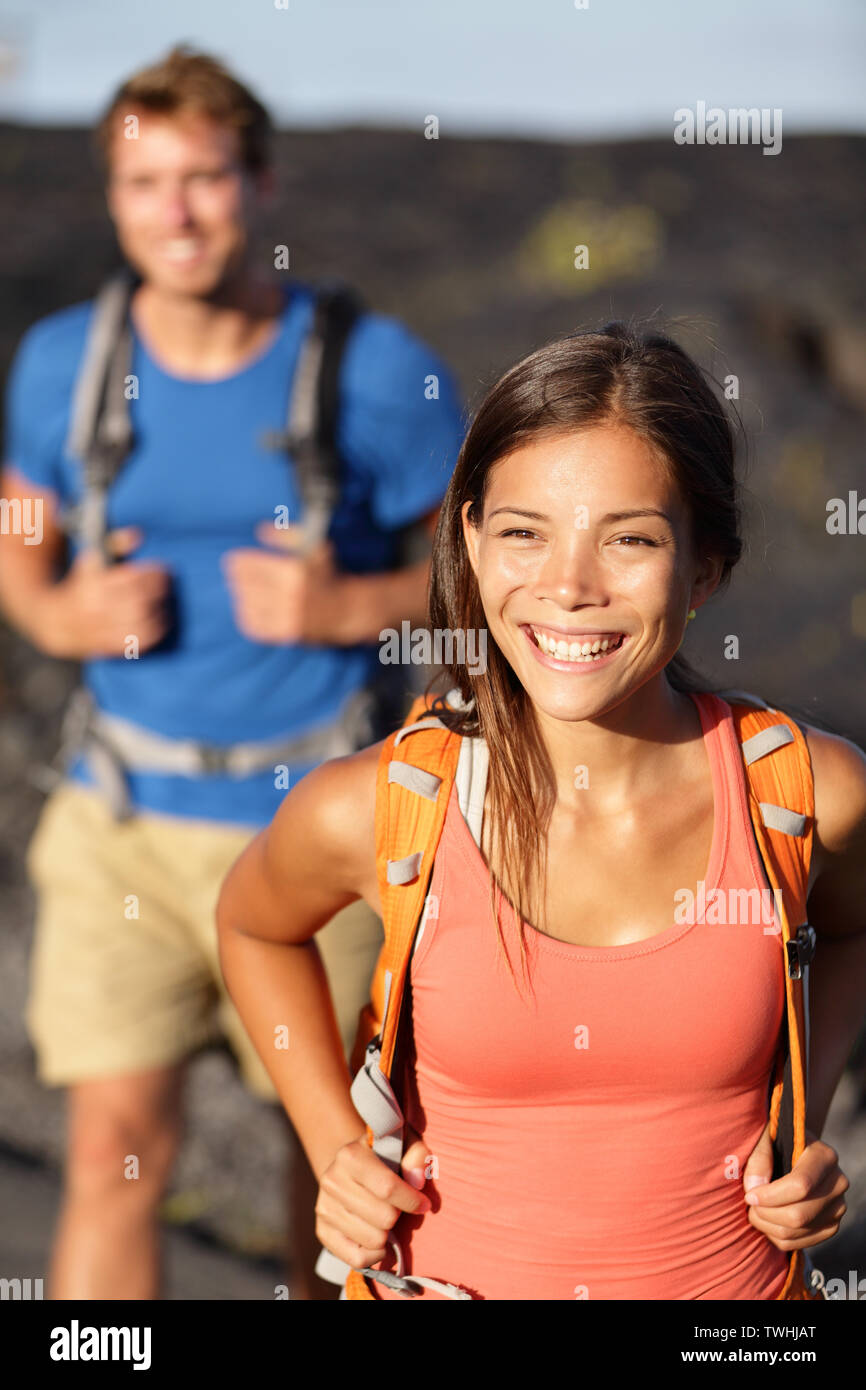 Escursionismo coppia - donna asiatica escursionista camminando sul campo lavico alle Hawaii. I turisti escursionisti sulla passeggiata vicino vulcano Kilauea intorno al Parco Nazionale dei Vulcani delle Hawaii, Stati Uniti d'America. Foto Stock