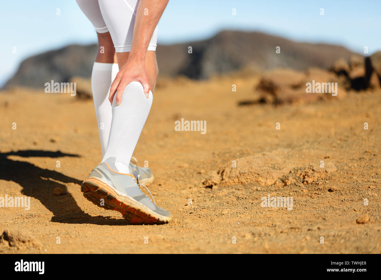 Esecuzione di crampi alle gambe o vitelli di distorsione sul polpaccio runner. Sport concetto di pregiudizio con esecuzione di uomo fitness atleta al di fuori. Foto Stock