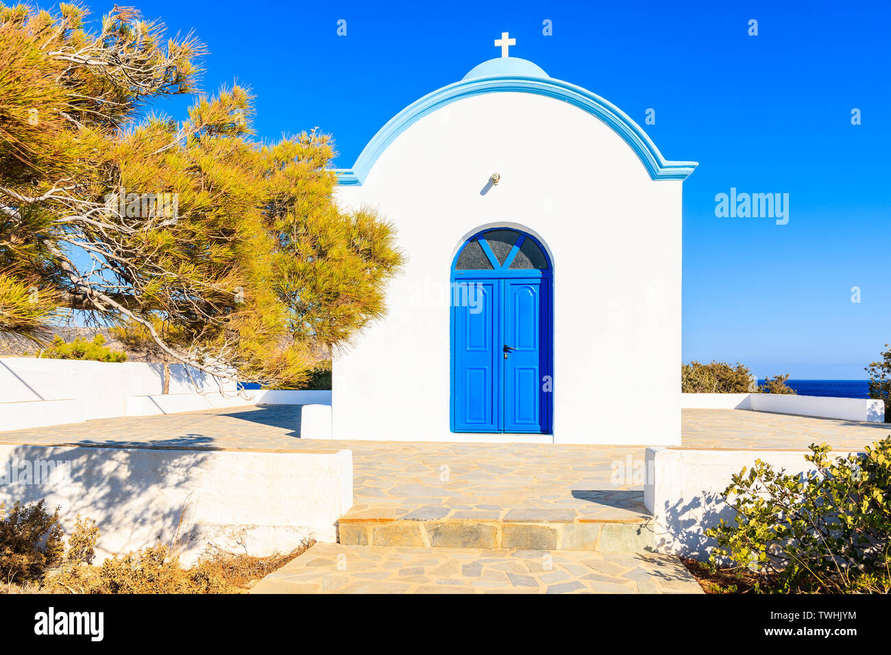 Facciata di colore bianco tipico greco chiesa con lo sportello blu sulla costa di Isola di Karpathos, Ammopi village, Karpathos Island, Grecia Foto Stock