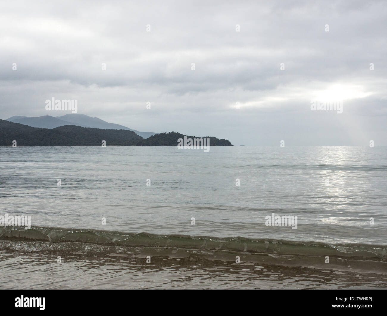 Ondata di acqua limpida, circa a rompere, al tramonto, in autunno, Lee Bay, Rakiura Isola Stewart, Nuova Zelanda Foto Stock