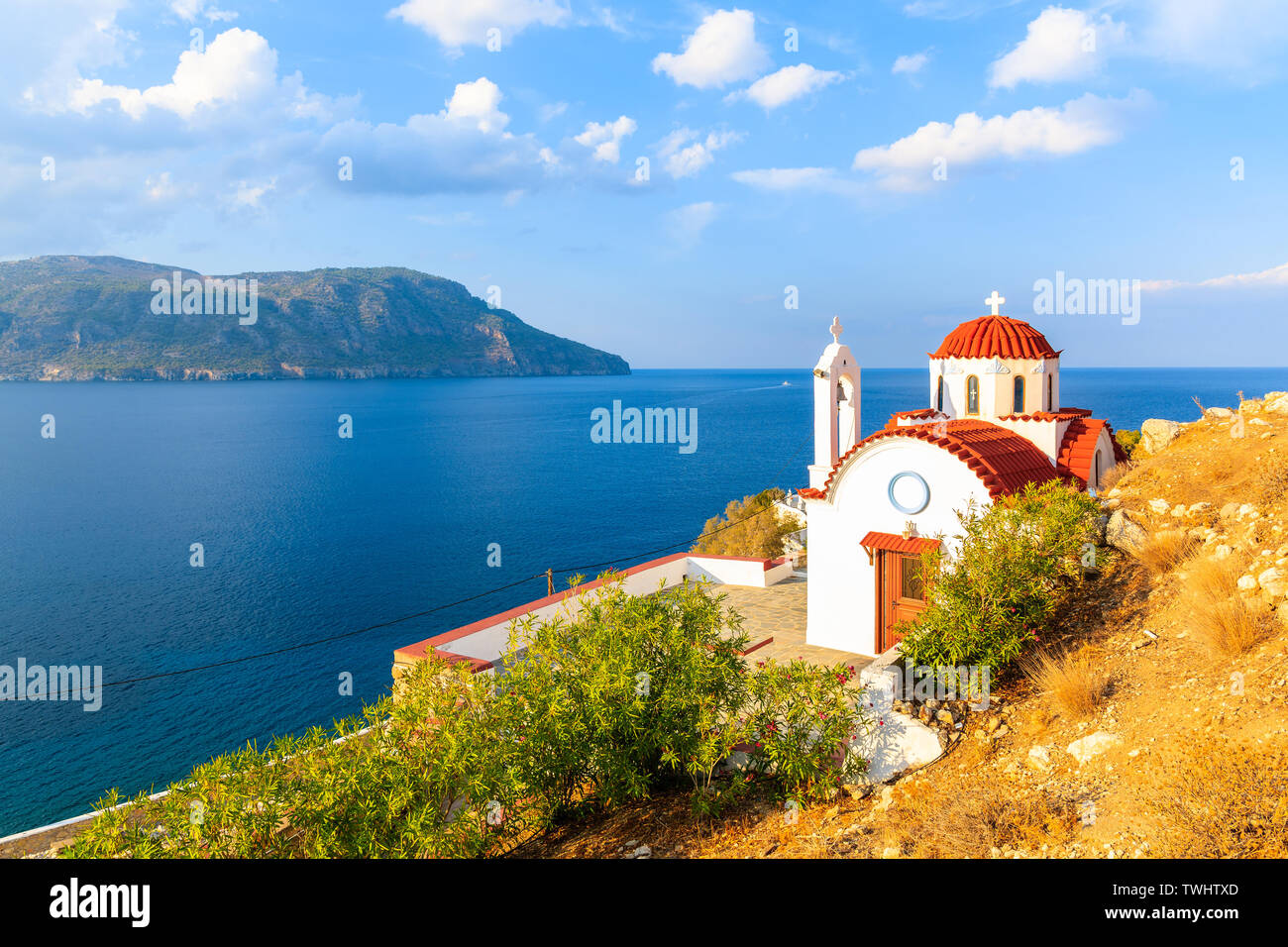 Chiesa bianca sulla scogliera alta sopra il mare vicino a Karpathos porto, Karpathos Island, Grecia Foto Stock
