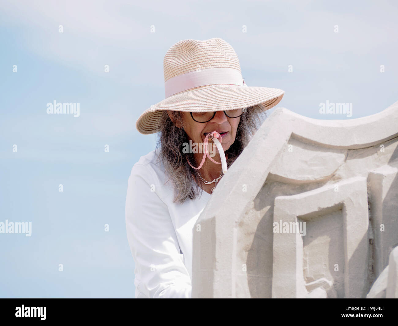 Lucinda Wierenga, imboccatura di un tubo di soffiaggio, scolpisce il suo maestro Duo voce, "Bow ai vostri padroni,' AL 2019 Texas Sandfest in Port Aransas, Texas, Stati Uniti d'America. Foto Stock