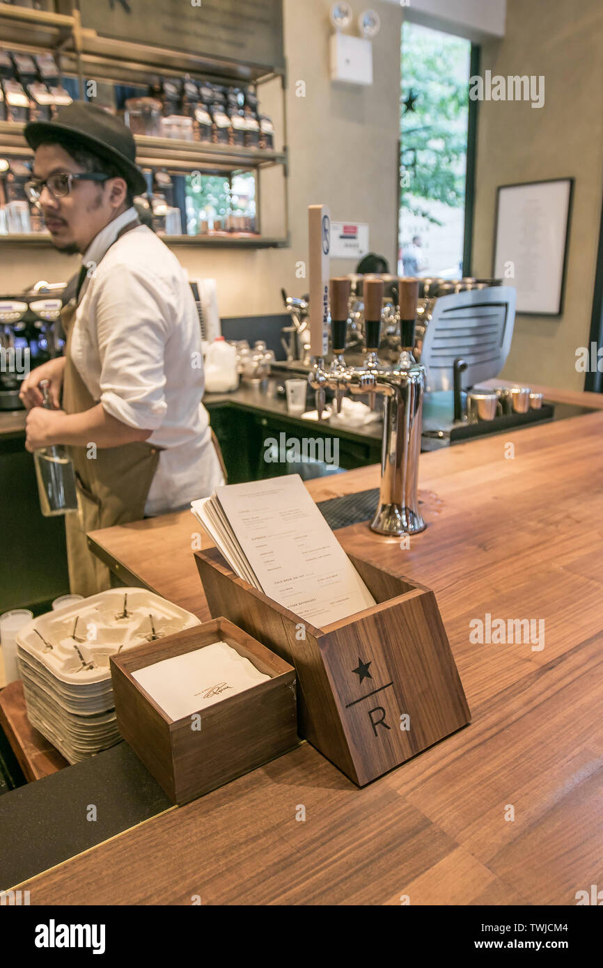 New York, 6/6/2019: barista di Starbucks di riserva è di fare il suo lavoro dietro un contatore. Foto Stock