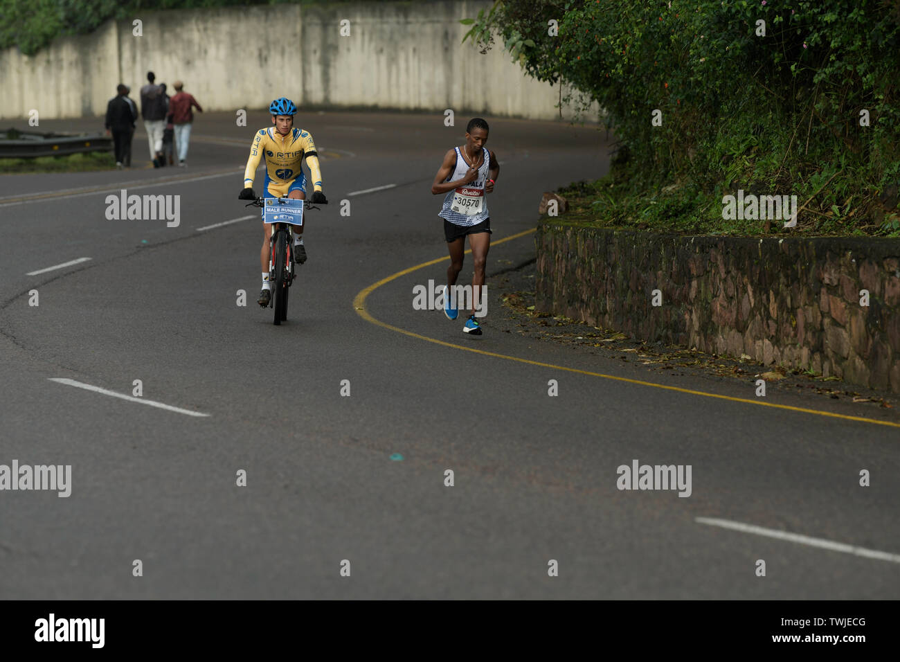 Durban, Sud Africa, maschio competitivo runner acceso al 2° posto a 37 km mark, 2019, compagni Marathon, azione, bicicletta, ciclista, persone Foto Stock