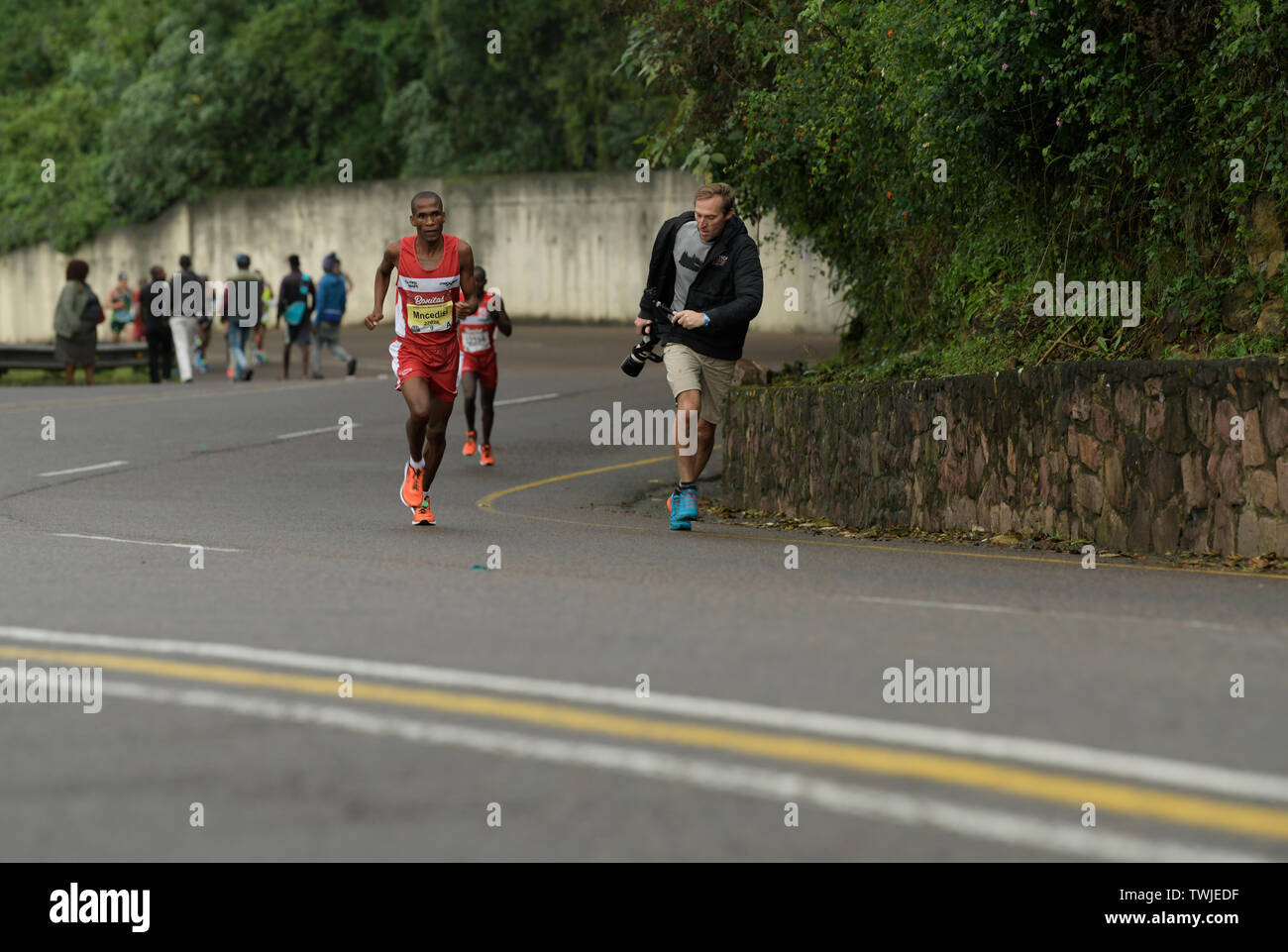 Durban, Sud Africa, delle guide di scorrimento nel 2019 compagni maratona, uomo con le riprese della telecamera durante l'esecuzione, persone di razza, concorrente, evento, riprese video Foto Stock