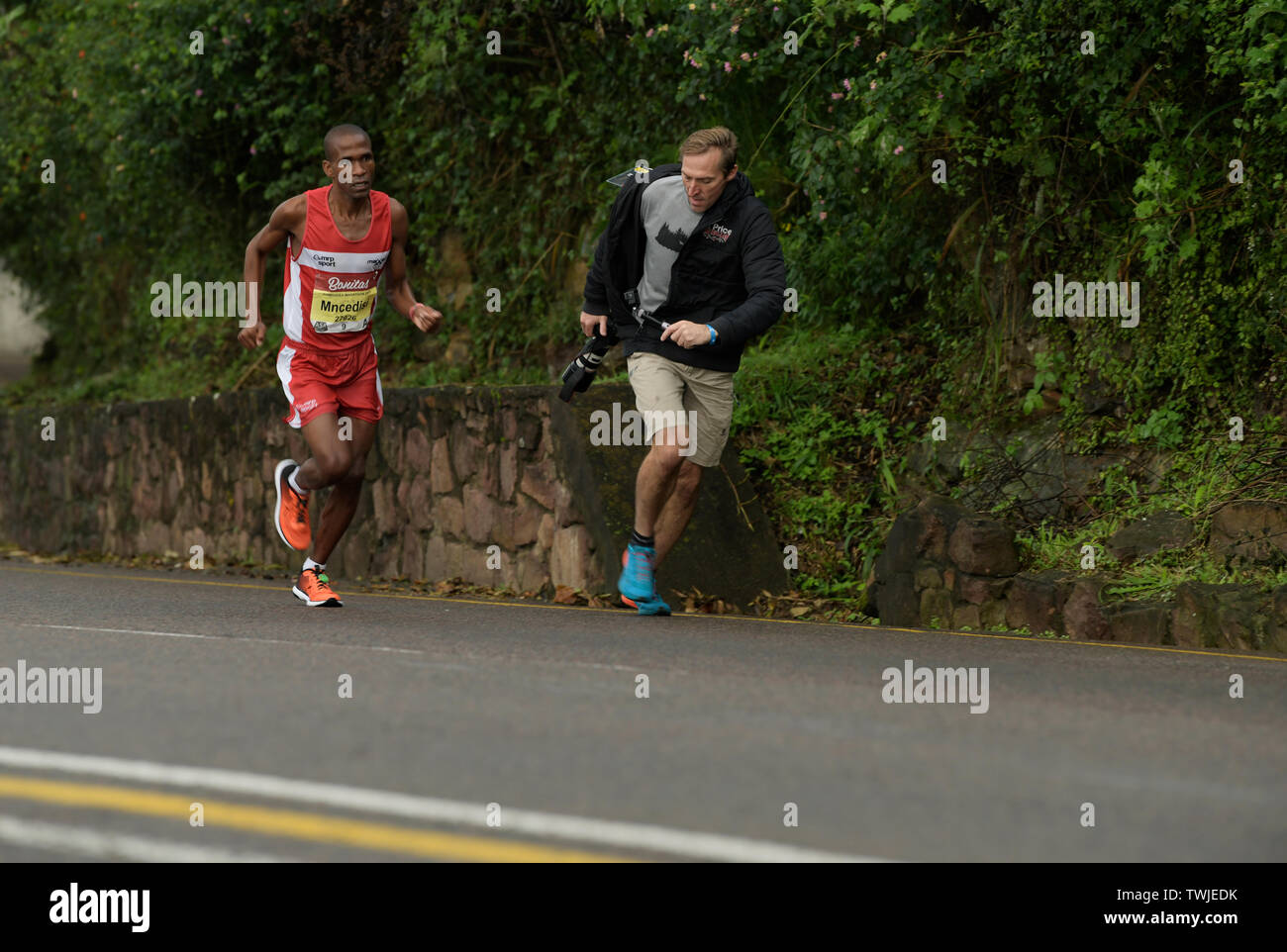 Durban, Sud Africa, uomo adulto in esecuzione con la telecamera durante le riprese di runner nel 2019 compagni maratona, concorrente, sport, le persone, azione, riprese video Foto Stock