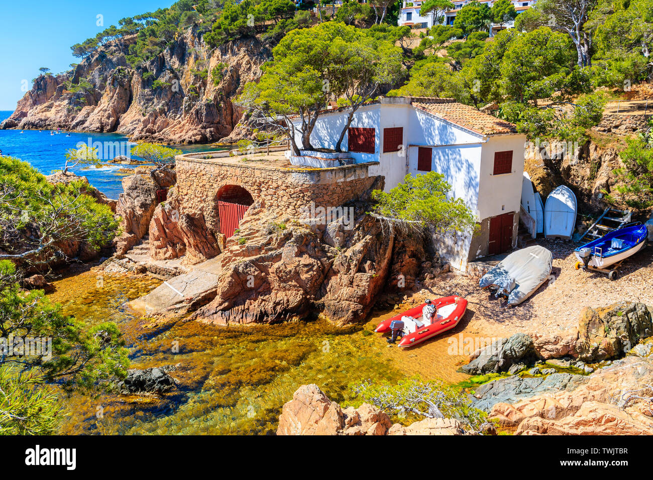Barche e white casa di pescatori sulla costa vicino a Cala Aigua, Costa Brava, Spagna Foto Stock