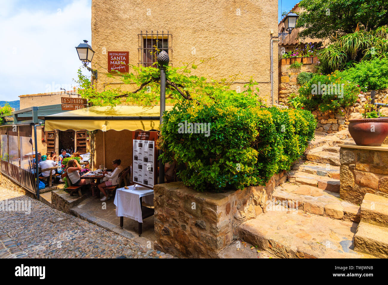 TOSSA DE MAR CITTÀ VECCHIA, Spagna - giu 3, 2019: Persone a pranzo nel ristorante nella città vecchia di Tossa de Mar con case in pietra, Costa Brava, Spagna. Foto Stock