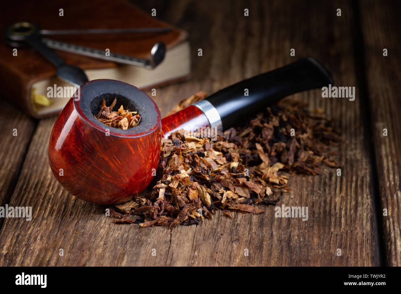 Laccato tubo di fumo di tabacco e la pila su vintage tavolo in legno. Copia dello spazio. Foto Stock