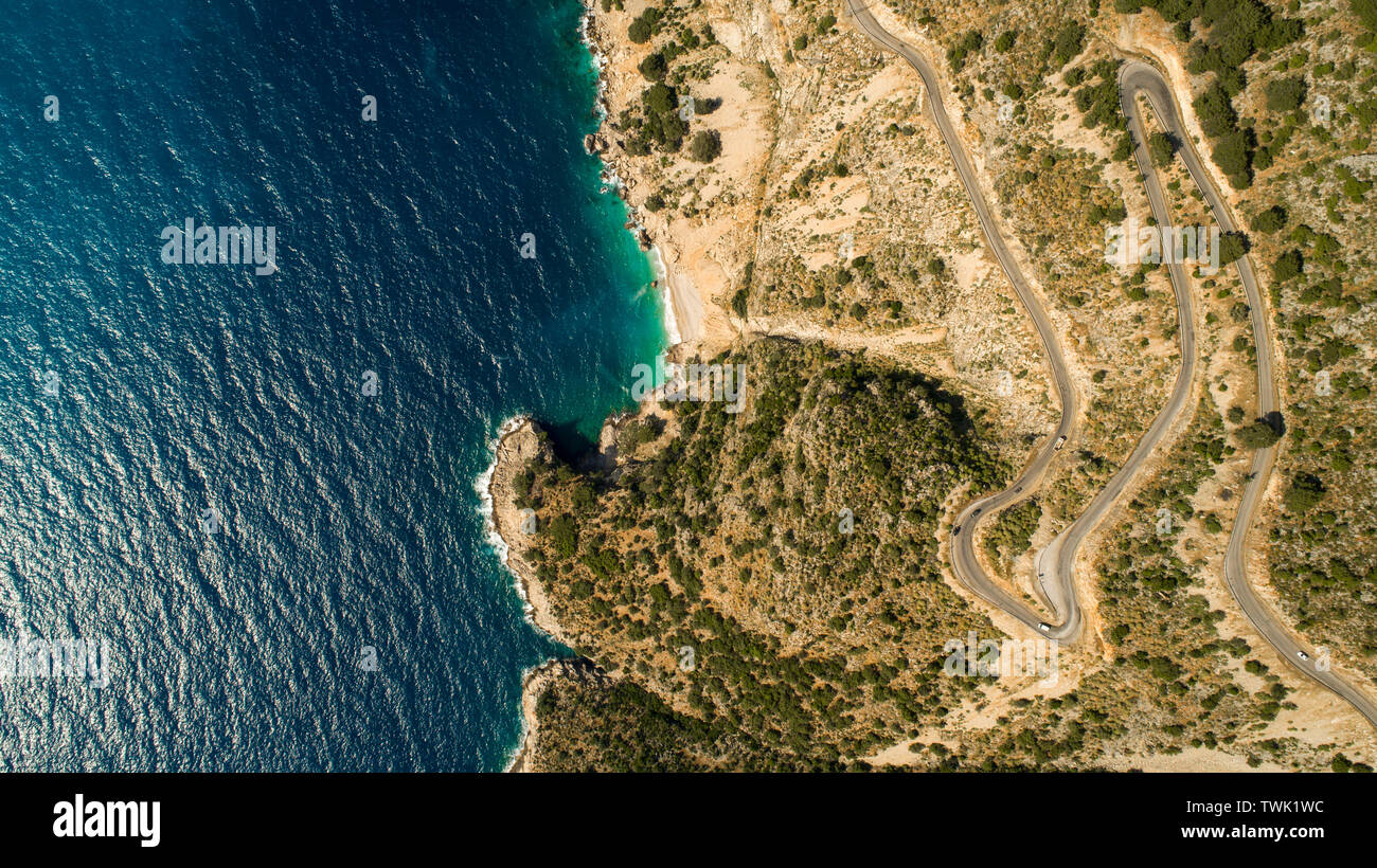 Paesaggio di antenna di costa e una strada seascape. Unità auto giù il vuoto di strada asfaltata che corre lungo la soleggiata costa mediterranea della Turchia. Foto Stock