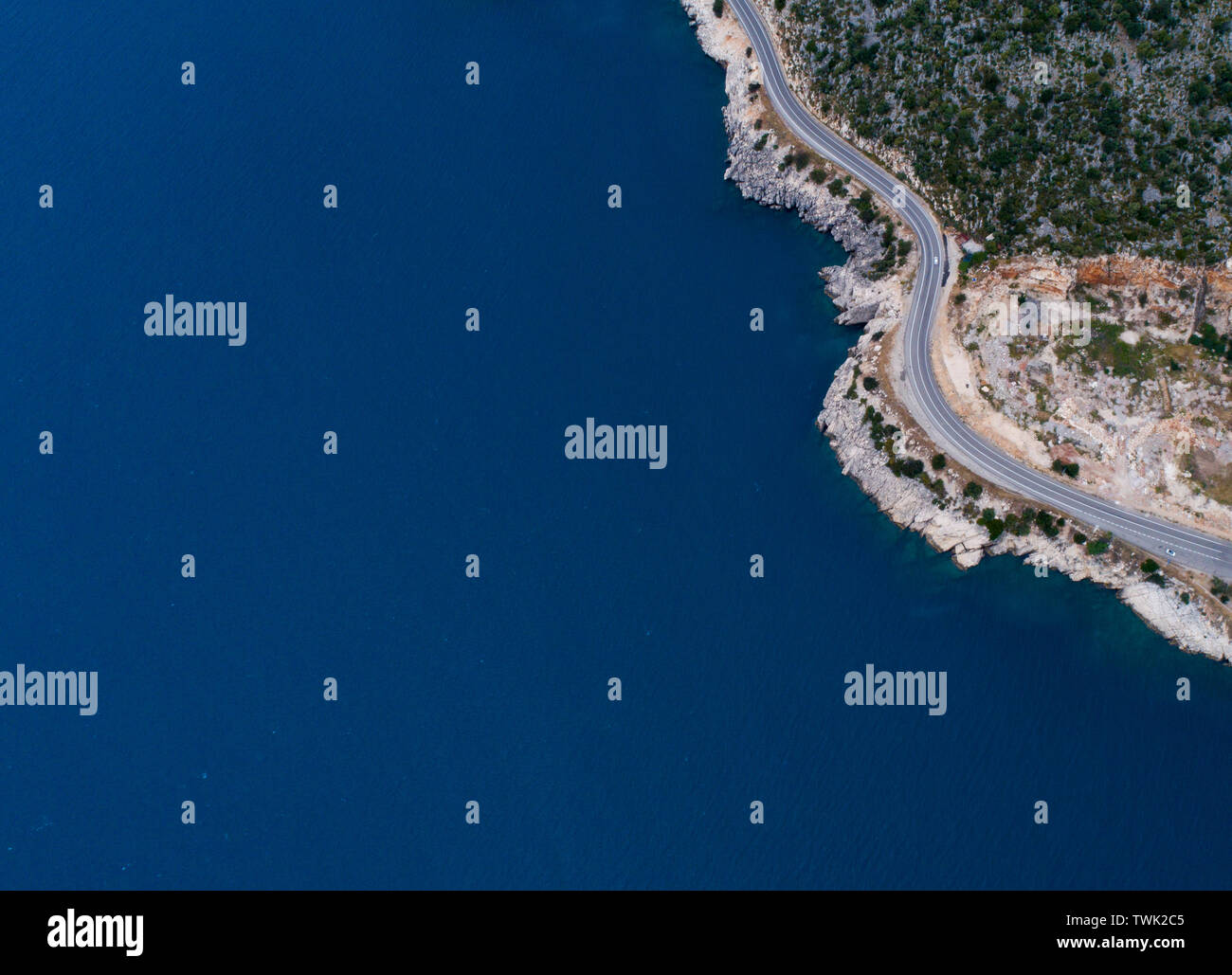 Paesaggio di antenna di costa e una strada seascape. Unità auto giù il vuoto di strada asfaltata che corre lungo la soleggiata costa mediterranea della Turchia. Foto Stock