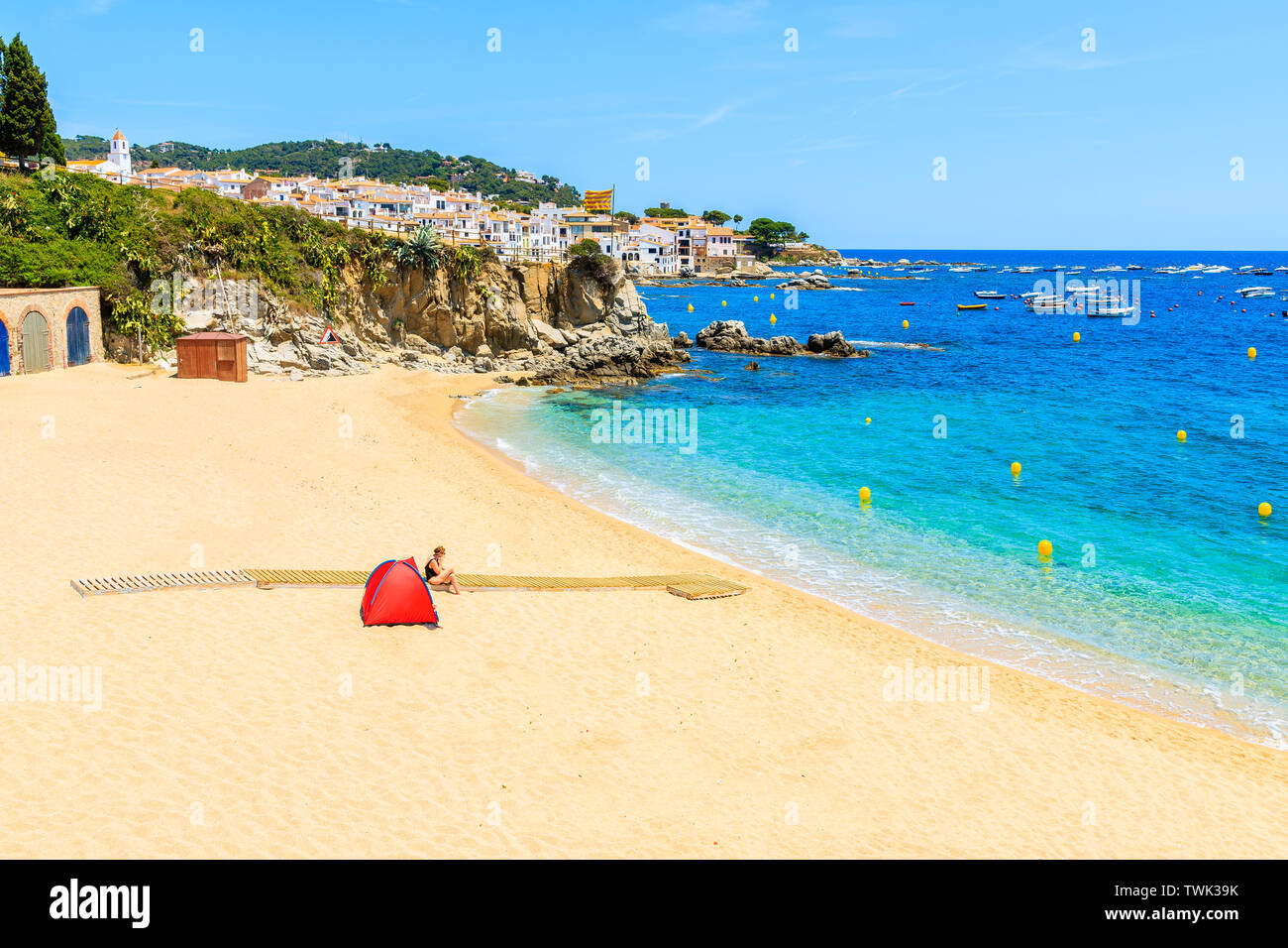 Tenda Rossa sulla splendida spiaggia di Calella de Palafrugell, scenic villaggio di pescatori con case bianche e la spiaggia di sabbia chiara con acqua blu, Costa Brava, Cata Foto Stock