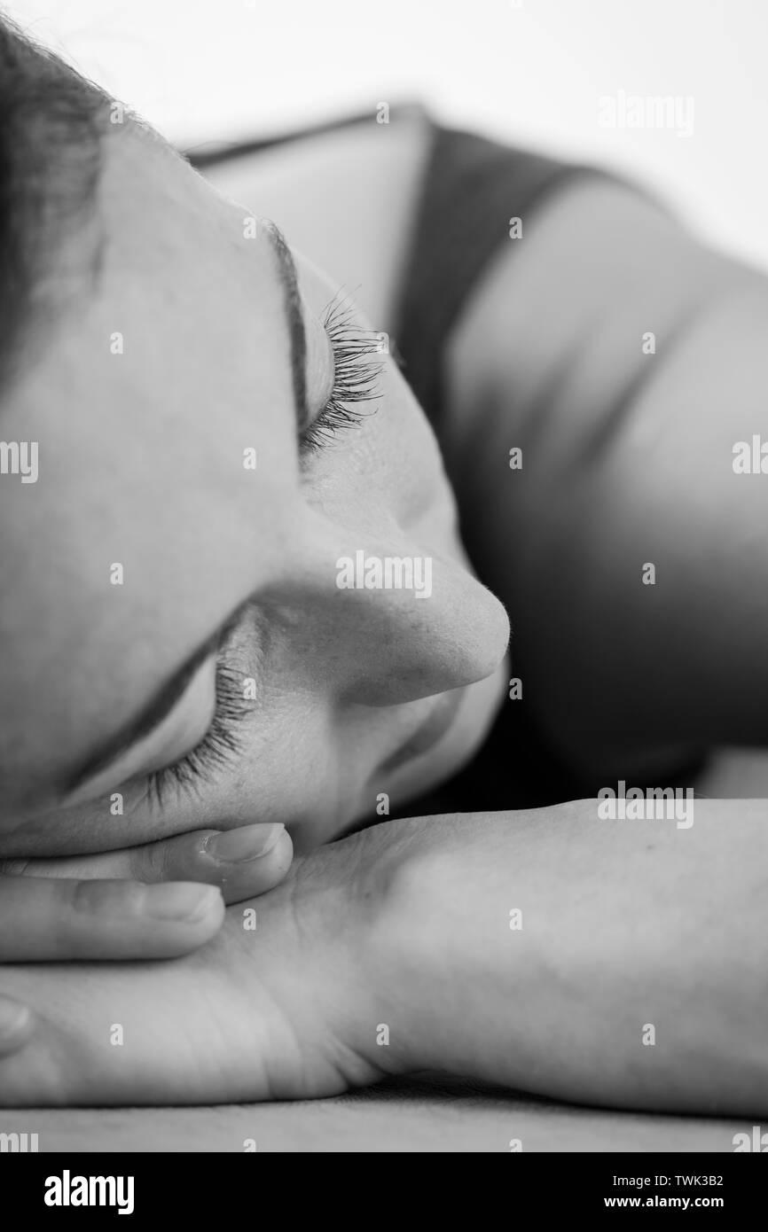 Ritratto in primo piano in bianco e nero della giovane donna della brunetta europea sul riposo profondo dopo la pratica dello yoga. Yoga nidra o Yogic sonno, meditazione guidata. Foto Stock