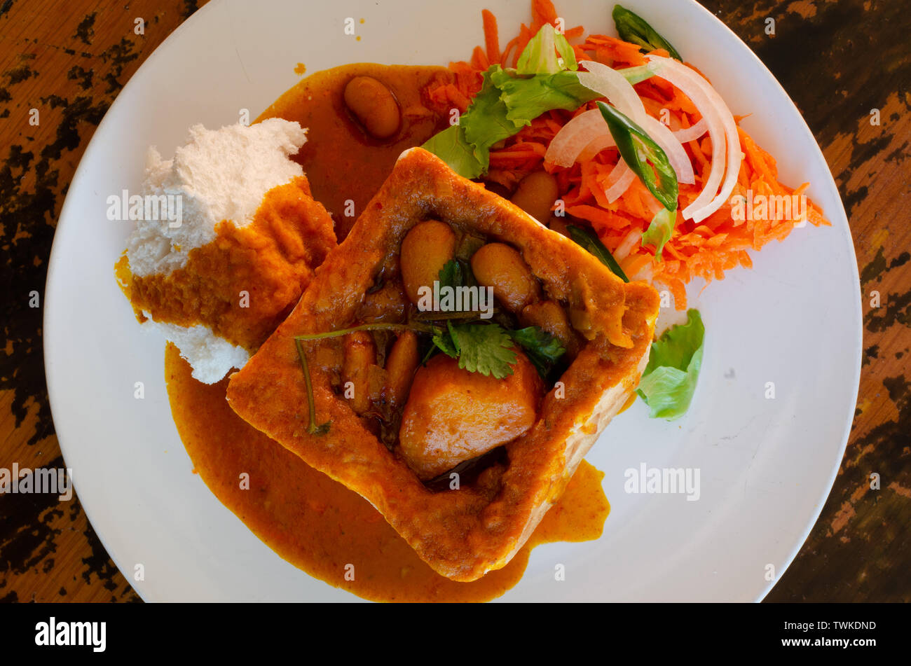 Un coniglietto di Durban Chow - o in questo caso un trimestre vegerarian bean bunny servita con sambals. Il piatto è realizzato da una scavata focaccia riempita con curry Foto Stock