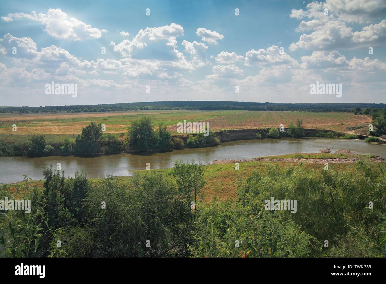 Paesaggio rurale, boccole, pascoli, sul fiume della foresta contro il cielo blu con nuvole Foto Stock