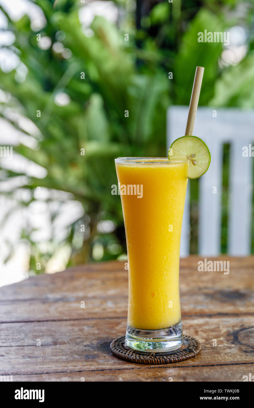 Succo di Mango in un bicchiere alto con bambù paglia, decorate con calce. Foto Stock